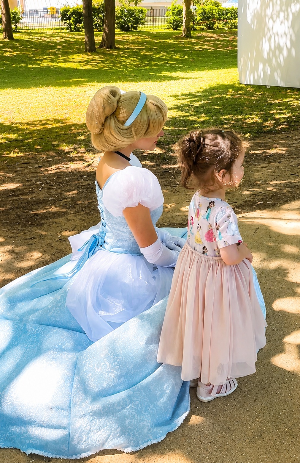 Animatrice costumée en Cendrillon avec une enfant, dans un parc